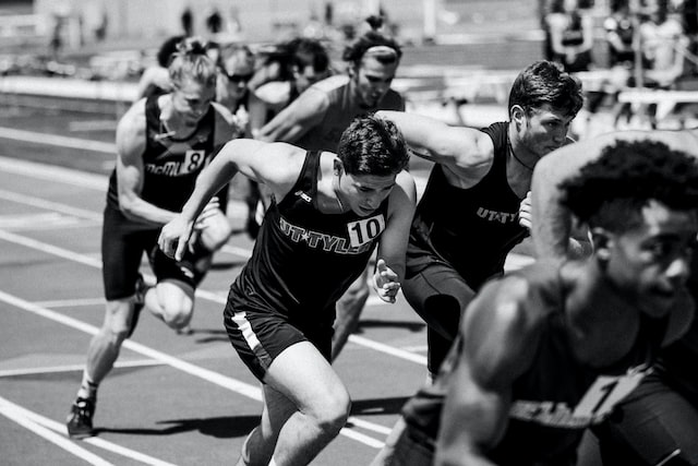 Runners in a competitive sprint start, showcasing determination and athleticism on a track field.