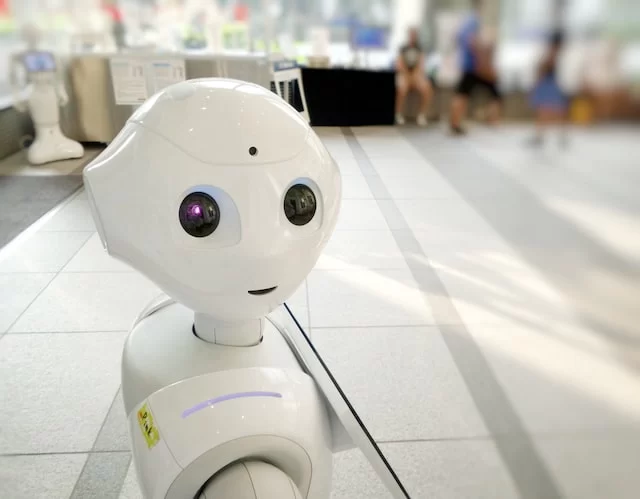 Robot with a friendly expression in a modern workspace, symbolizing robotic process automation (RPA) for small and medium-sized businesses.